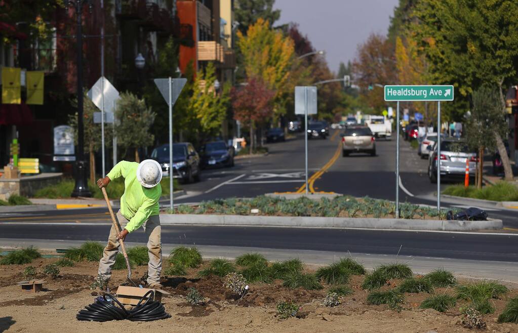 Ignacio Aguirre works on the landscaping in the new roundabout at Healdsburg Avenue, at Vine and Mill streets, in Healdsburg on Thursday, November 8, 2018. (Christopher Chung / The Press Democrat)