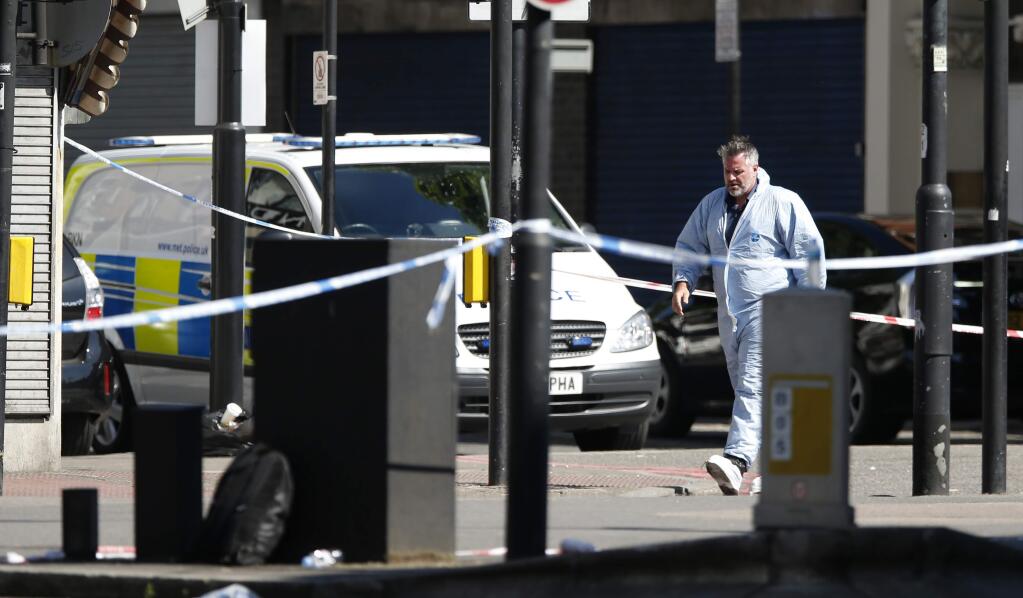 A forensic officer leaves the scene where a van struck pedestrians in Finsbury Park, north London, Monday, June 19, 2017. London police, already stretched by a series of major incidents around the capital, are putting more officers on the street to reassure the public after a driver plowed into a crowd of people leaving a mosque early Monday. One man died at the scene and 10 people were injured. (AP Photo/Alastair Grant)