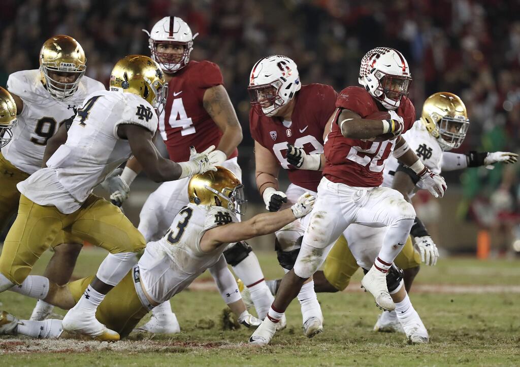Stanford running back Bryce Love (20) breaks through the line for a first down against Notre Dame during the second half Saturday, Nov. 25, 2017. Stanford won 38-20. (AP Photo/Tony Avelar)