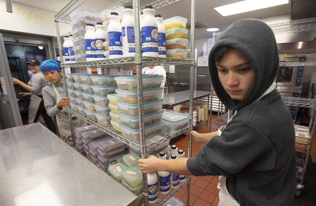 Teen volunteers, wheel out a rack of packaged meals for the low-income ill clients at the Ceres Community Project in Sebastopol. (photo by John Burgess/The Press Democrat)