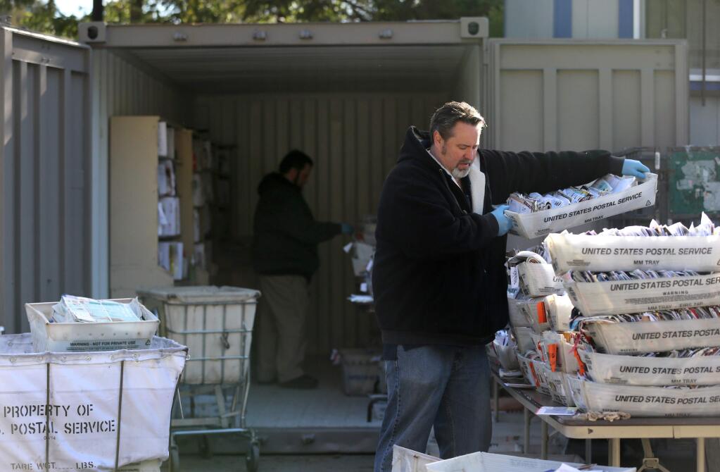 Jimmy Cravens, a postal clerk in Monte Rio, works at the temporary U.S. Post Office set up in trailers behind the flood-damaged building in Guerneville on Tuesday, March 12, 2019. (BETH SCHLANKER/ The Press Democrat)