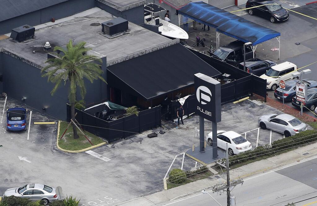FILE - In this June 12, 2016 file photo, law enforcement officials work at the Pulse gay nightclub in Orlando, Fla., following a mass shooting. A California judge is deciding whether to release the widow of the gunman, Omar Mateen, who killed dozens of people at the Florida nightclub and is accused of helping him. A hearing is set in federal court in Oakland, Calif., on Wednesday, March 1, 2017, to determine whether Noor Salman must stay behind bars while she awaits trial. (AP Photo/Chris O'Meara, File)
