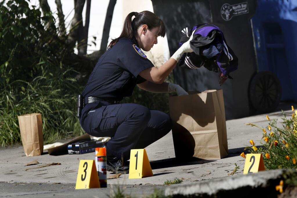 Police evidence technician Allisha Galvan bags bloodied clothes at the scene of a slaying on Red Tail Street in Santa Rosa on Monday, May 11, 2015. (BETH SCHLANKER/ PD)