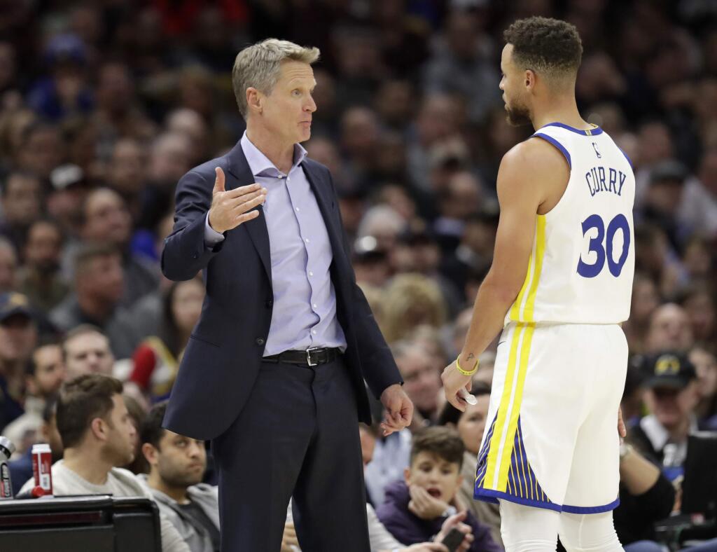 Golden State Warriors head coach Steve Kerr, left, talks with Stephen Curry in the second half against the Cleveland Cavaliers, Monday, Jan. 15, 2018, in Cleveland. (AP Photo/Tony Dejak)