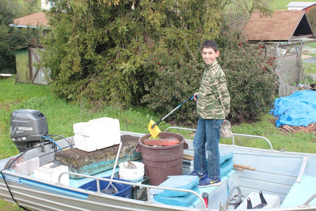 DJ Woodbury displays just some of the items in the more than 2,200 pounds of garbage he fished from the Petaluma River as part of his Petaluma Live Oak Charter School service project on Feb. 5, 2017. (FAMILY PHOTO)