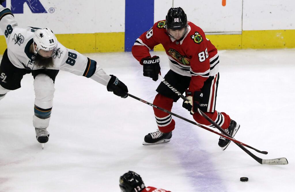 Chicago Blackhawks right wing Patrick Kane, right, controls the puck against San Jose Sharks defenseman Brent Burns during the third period Friday, Feb. 23, 2018, in Chicago. The Blackhawks won 3-1. (AP Photo/Nam Y. Huh)