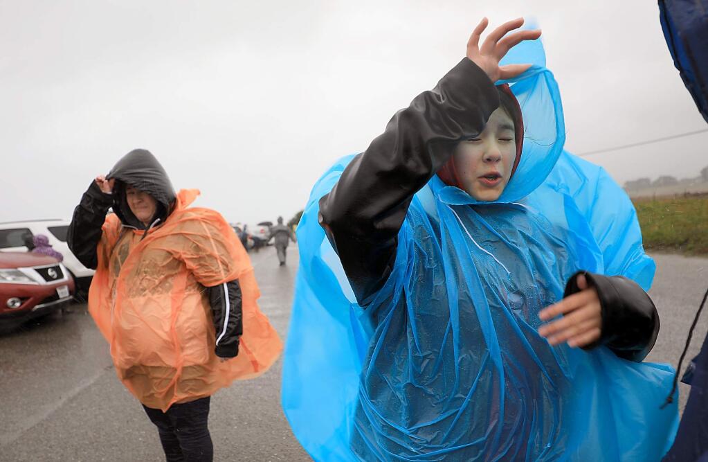 Amber Munoz, left, and Jazmine Munoz, react as they fight against the wind and rain, as mother and daughter join others on an outing from Antioch Charter School of Antioch. The group cut their visit short to Salmon Creek State Beach north of Bodega Bay, Wednesday Jan. 16, 2019. (Kent Porter / The Press Democrat) 2019