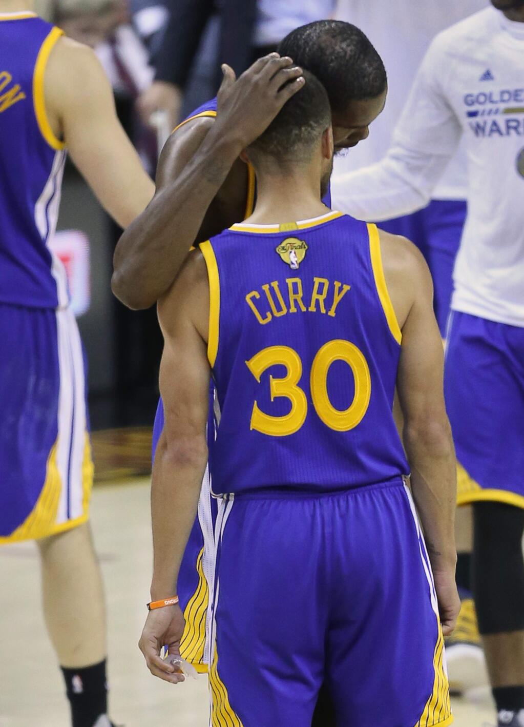 Golden State Warriors forward Kevin Durant hugs Golden State Warriors guard Stephen Curry after Curry hit his free throws at the end of the fourth quarter against the Cleveland Cavaliers, during Game 3 of the NBA Finals in Cleveland on Wednesday, June 7, 2017. The Warriors defeated the Cavaliers 118-113.(Christopher Chung/ The Press Democrat)