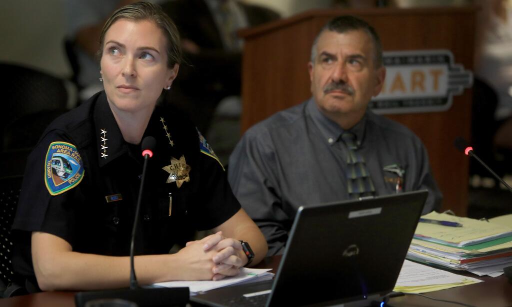 Jennifer McGill, SMART's chief of police, and agency General Manager Farhad Mansourian, watch a video during a SMART board meeting during a presentation about deaths on the SMART tracks. (Kent Porter / The Press Democrat, 2019)