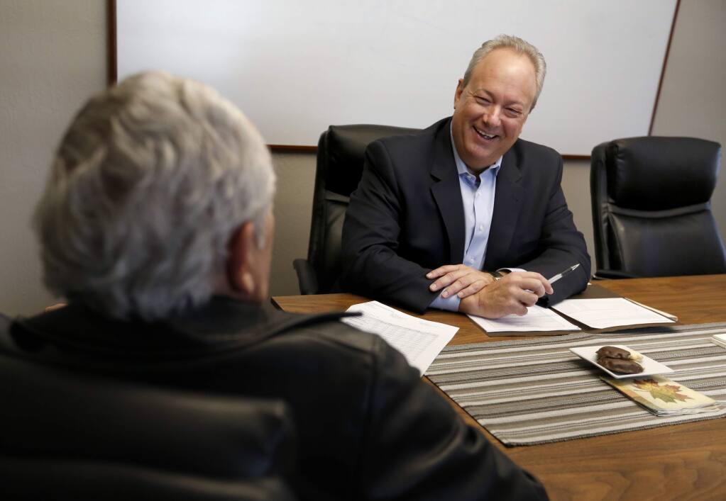 David Brown, right, a certified financial planner and an accredited investment fiduciary, with Encore Wealth Management, goes over a quarterly portfolio report with his client Allen Goldberg at his office in Santa Rosa, on Tuesday, December 6, 2016. (BETH SCHLANKER/ The Press Democrat)