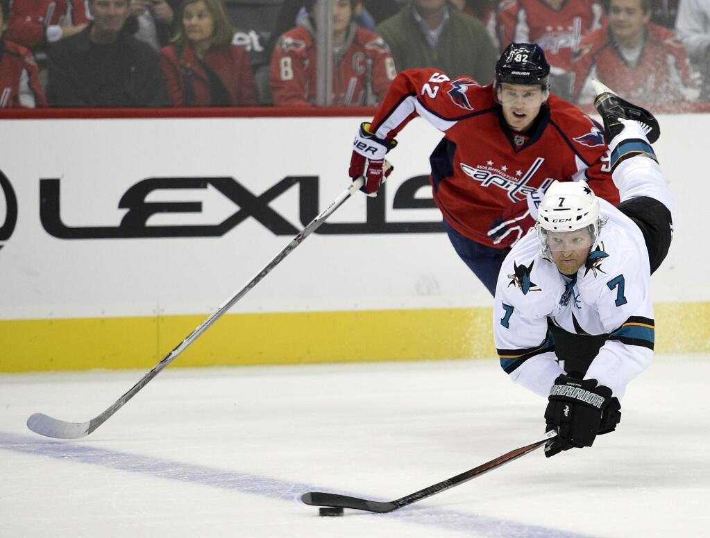 San Jose Sharks defenseman Paul Martin (7) reaches for the puck against Washington Capitals center Evgeny Kuznetsov (92), of Russia, during the first period of an NHL hockey game, Tuesday, Oct. 13, 2015, in Washington. (AP Photo/Nick Wass)