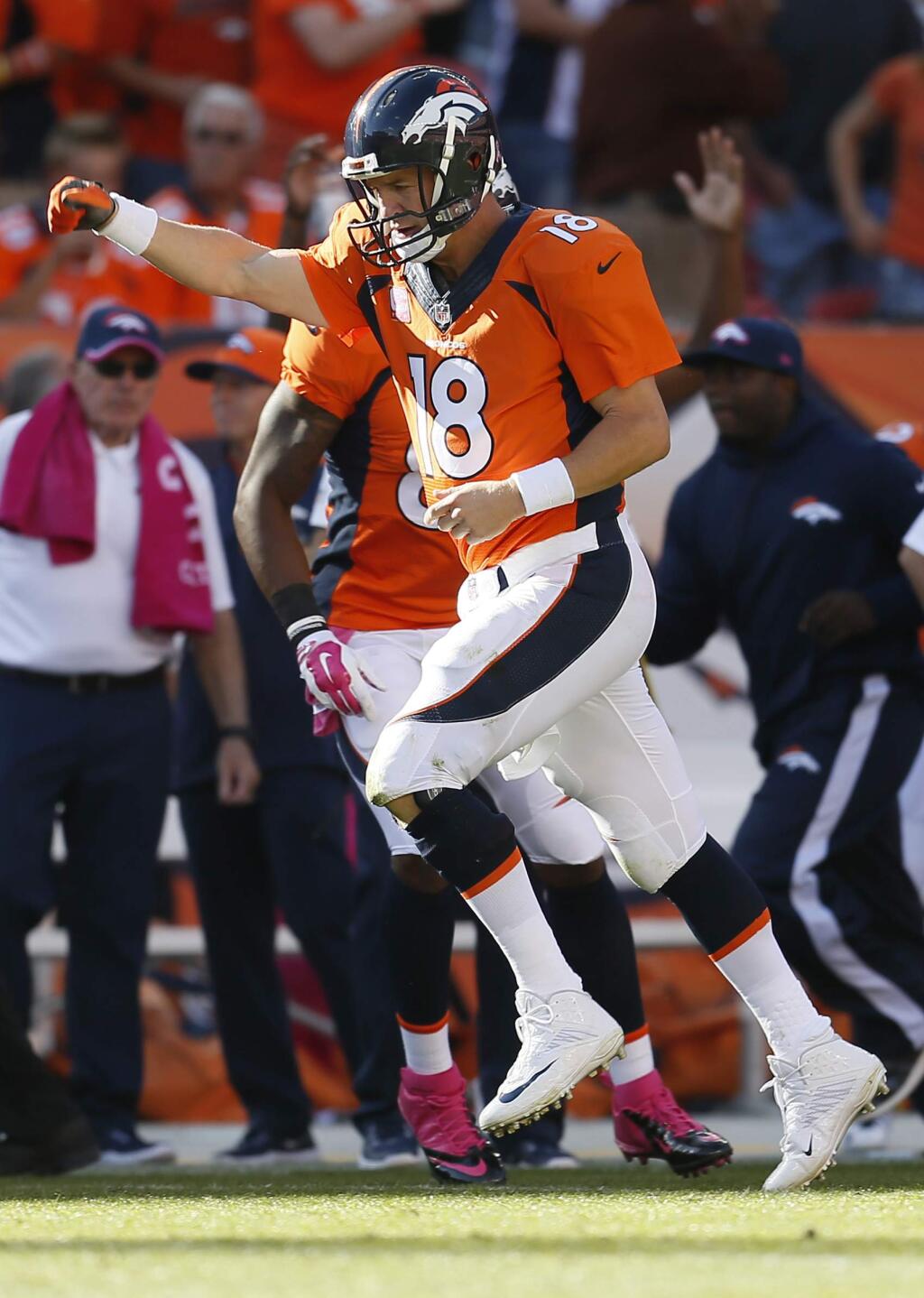 FILE - In this Oct. 5, 2014, file photo, Denver Broncos quarterback Peyton Manning (18) runs upfield after a touchdown pass against the Arizona Cardinals during the second half of an NFL football game in Denver. Next Sunday, Oct. 19, 2014, against San Francisco, or perhaps the following Thursday against San Diego, Manning will surpass Brett Favre's NFL record 508 touchdown passes. Manning is two shy after throwing for three scores in a 31-17 victory over the New York Jets on Sunday. (AP Photo/Joe Mahoney, File)