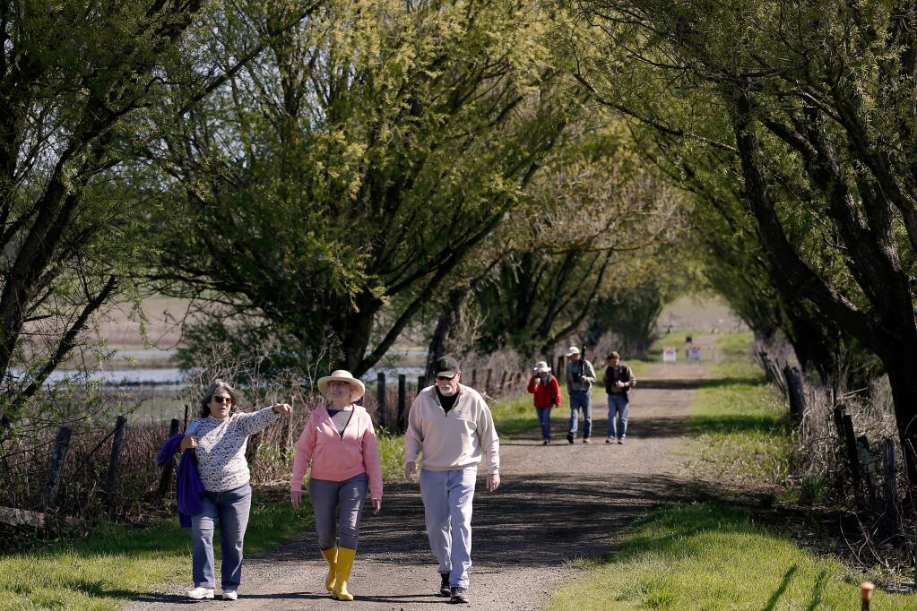 Patricia Webb, left, Cathleen Springer, Gary Moeller and other visitors walk along the Causeway Trail before the dedication of Tolay Lake Regional Park in Petaluma, California, on Saturday, March 30, 2019. (Alvin Jornada / The Press Democrat)