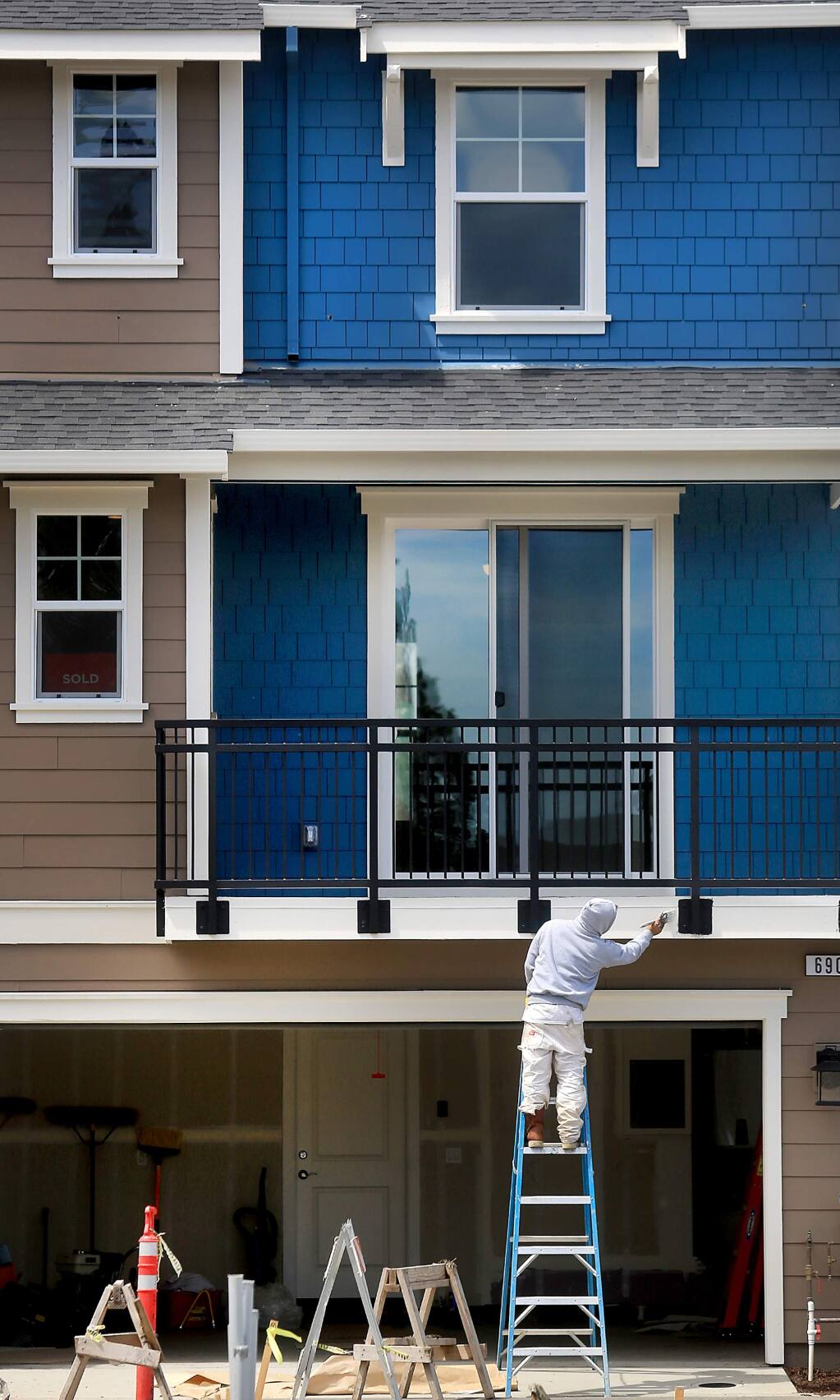 Jaime Martinez Lopez paints trim on a townhouse at Village Walk in Cotati, Thursday April 27, 2017, one of 46 townhomes and single family homes by Synergie Communities. (Kent Porter / The Press Democrat) 2017