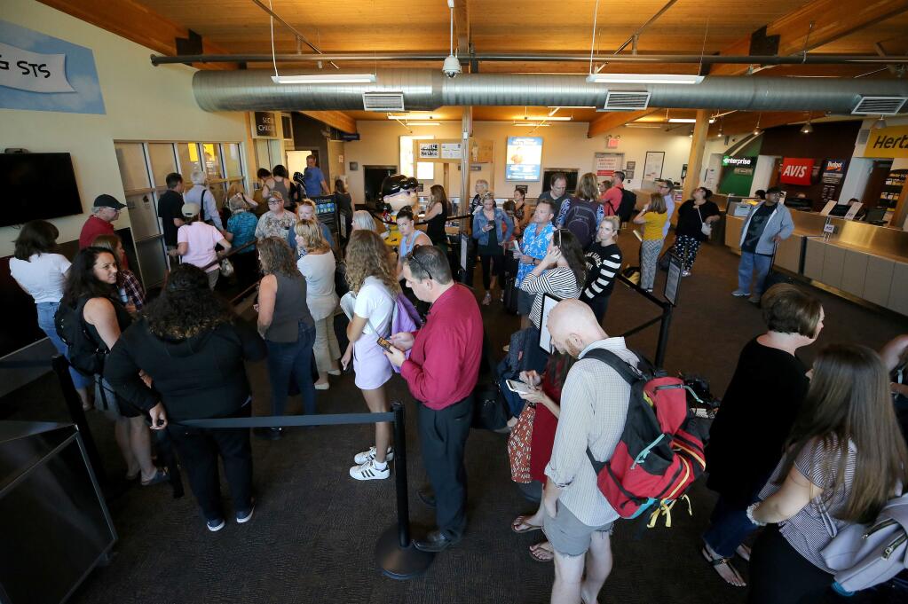 Passengers wait in the security line while TSA hand-checks bags after the scanner stopped working at the Charles M. Schulz–Sonoma County Airport in Santa Rosa on Tuesday, July 23, 2019. (BETH SCHLANKER/ PD)
