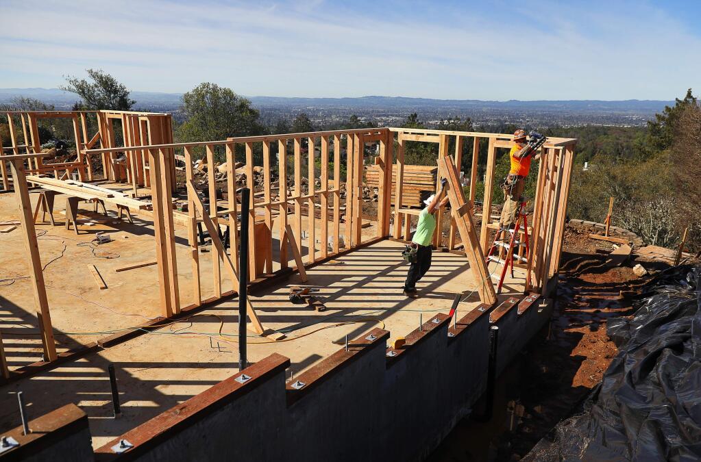 Arron Hopper, left, and Greg Bergstrom, both with Richard Hancock, Inc., work on the framing of a home being rebuilt on Shillingford Place, in the Fountaingrove area of Santa Rosa on Monday, March 19, 2018. (Christopher Chung/ The Press Democrat)