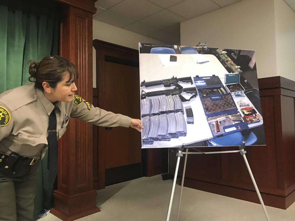 Deputy Lisa Jansen displays photos of weapons and ammo at a news conference in Los Angeles on Wednesday, Feb. 21, 2018. Authorities say they've thwarted a student's plot for a mass shooting at a Southern California high school. The Los Angeles County Sheriff's Department said Tuesday that a security guard at El Camino High School in Whittier overhead a 'disgruntled student' threaten to open fire on the school on Friday, just two days after 17 people were gunned down at a Florida high school. Sheriff's spokeswoman Nicole Nishida tells The Associated Press that deputies discovered 'multiple guns and ammunition' after searching the student's home..(AP Photo/Mike Balsamo)