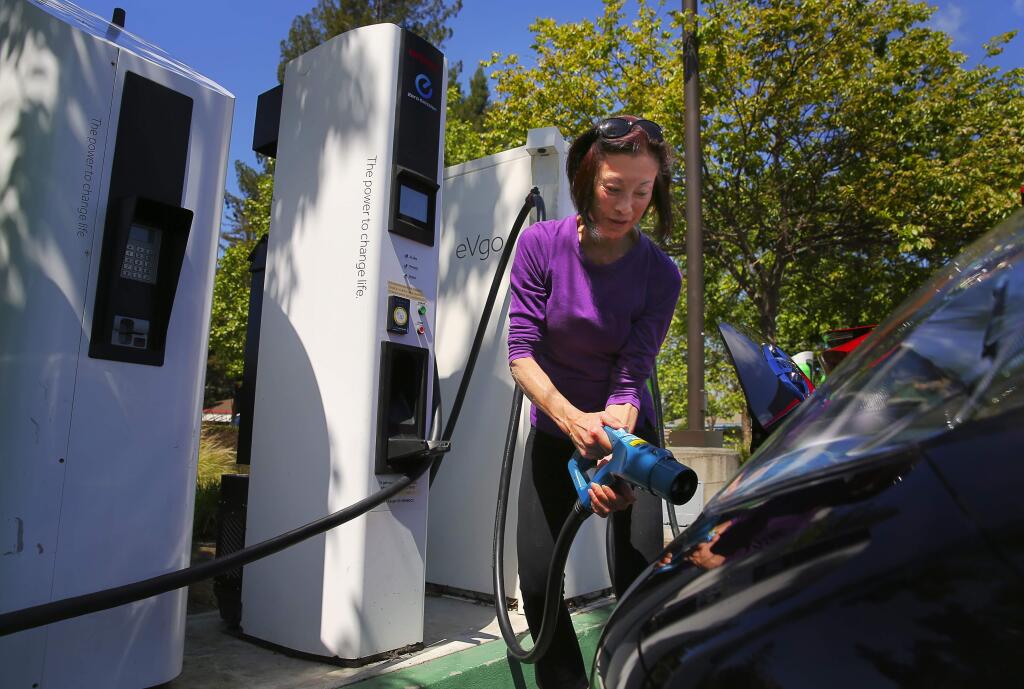 Lorna Ho uncouples her electric vehicle from a charging station in the parking lot of Coddingtown Mall, in Santa Rosa, on Thursday, April 20, 2017. (Christopher Chung/The Press Democrat)