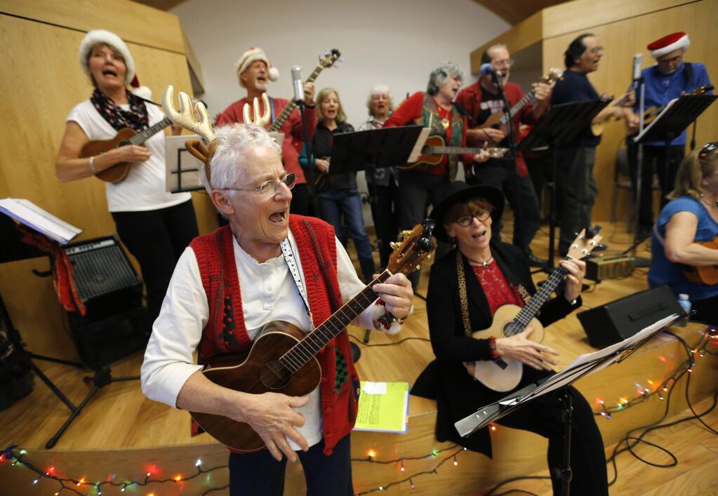 Julee Fullenwider plays Christmas music with members of the Ukulelians during a sing-a-long and potluck for area ukelele groups. The event took place at the Finley Community Center in Santa Rosa, on Monday, December 12, 2016. (BETH SCHLANKER/ The Press Democrat)