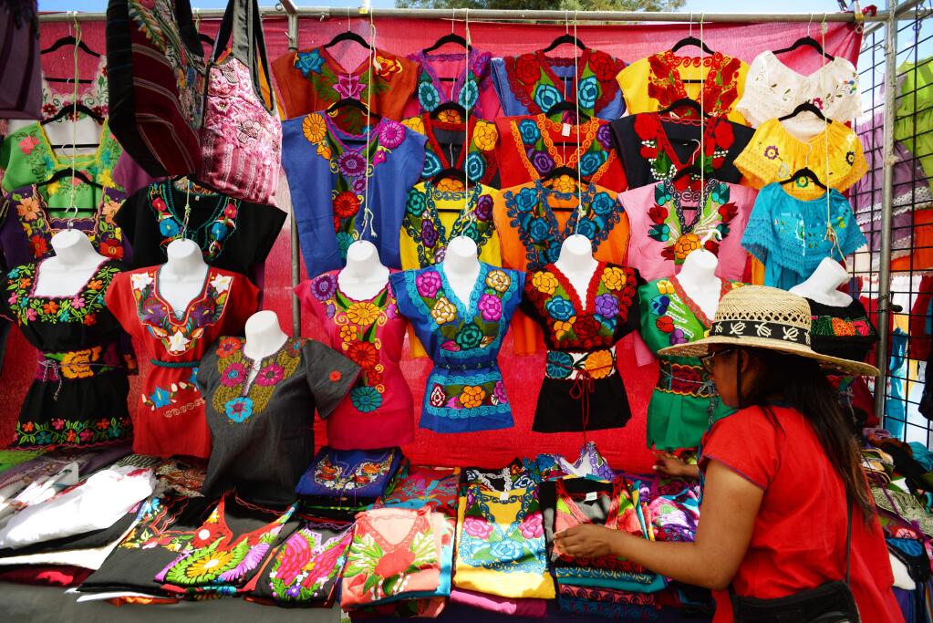 Gabby Torres, of Bakersfield, California selling Oaxacan made clothing at her stand 'A Piece of Mexico,' during the 6th Guelaguetza Sonoma County 2017; a festival celebrating the diverse traditions from the state of Oaxaca, Mexico. The event was organized by Oaxaca Tierra del Sol and held Sunday at the Luther Burbank Center for the Arts in Santa Rosa, California. July 16 2017.(Photo: Erik Castro/for The Press Democrat)