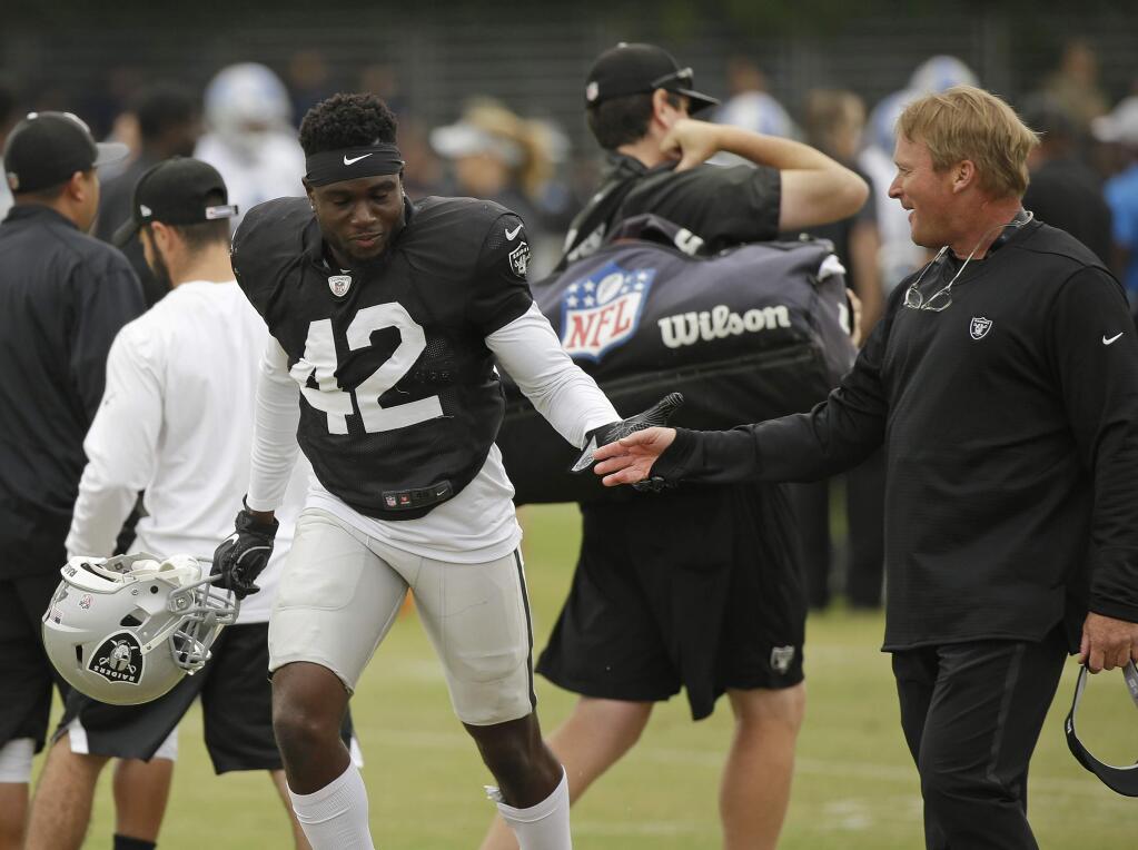 Oakland Raiders head coach Jon Gruden, right, greets defensive back Karl Joseph (42) during NFL football practice Wednesday, Aug. 8, 2018, in Napa, Calif. Both the Oakland Raiders and the Detroit Lions held a joint practice before their upcoming preseason game on Friday. (AP Photo/Eric Risberg)