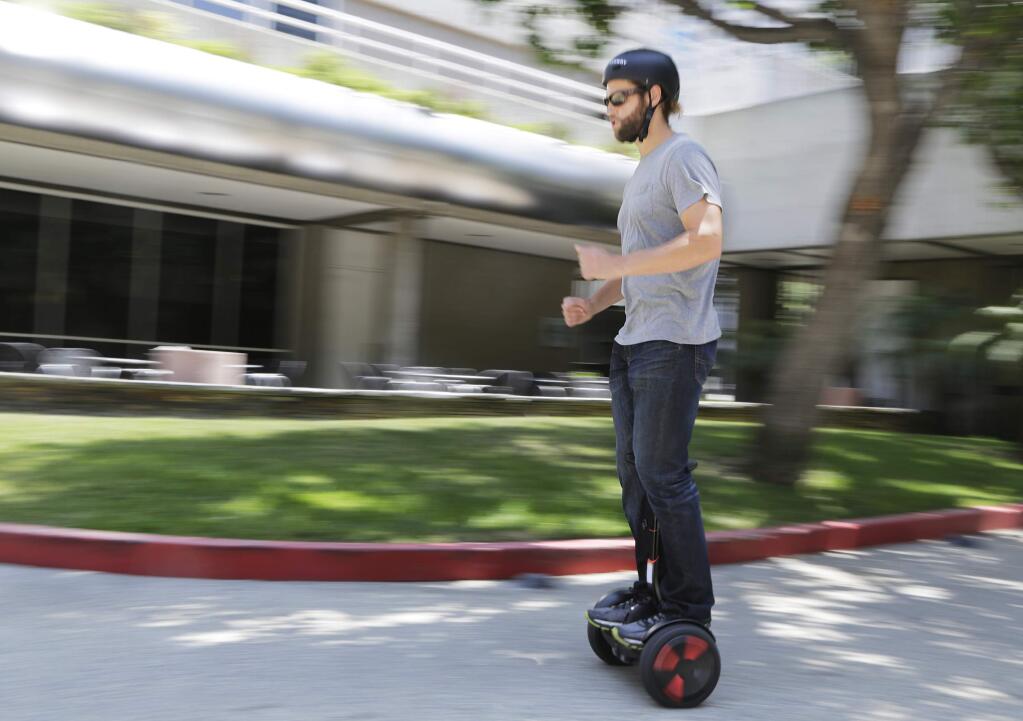 In this May 27, 2016, photo, company representative Zach Servideo demonstrates Segway's new self-balancing scooter, the MiniPro, in downtown Los Angeles. The MiniPro is going on sale on Amazon, Wednesday, June 1, 2016. Hoverboards are attempting a comeback in the U.S., months after videos showing them bursting into flame went viral. (AP Photo/Reed Saxon)