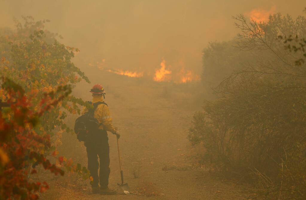 A fire captain from Santa Monica Fire Department keeps an eye on burning vegetation on Joe Valera's ranch off Los Amigos Road in Windsor, California, on Sunday, Oct. 27, 2019. (ALVIN JORNADA/ PD)