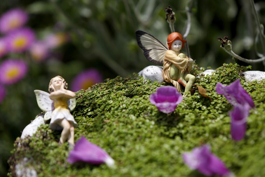 Fairy figurines sit perched on the edge of a birdbath filled with plants in the garden at Muirs Tea Room in Sebastopol, on Wednesday, May 27, 2015. (BETH SCHLANKER/ The Press Democrat)