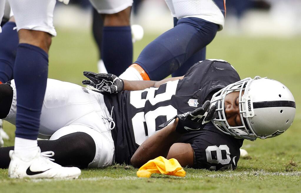 Oakland Raiders wide receiver Amari Cooper remains on the ground after a hit by the Denver Broncos during the first half in Oakland, Sunday, Nov. 26, 2017. (AP Photo/D. Ross Cameron)