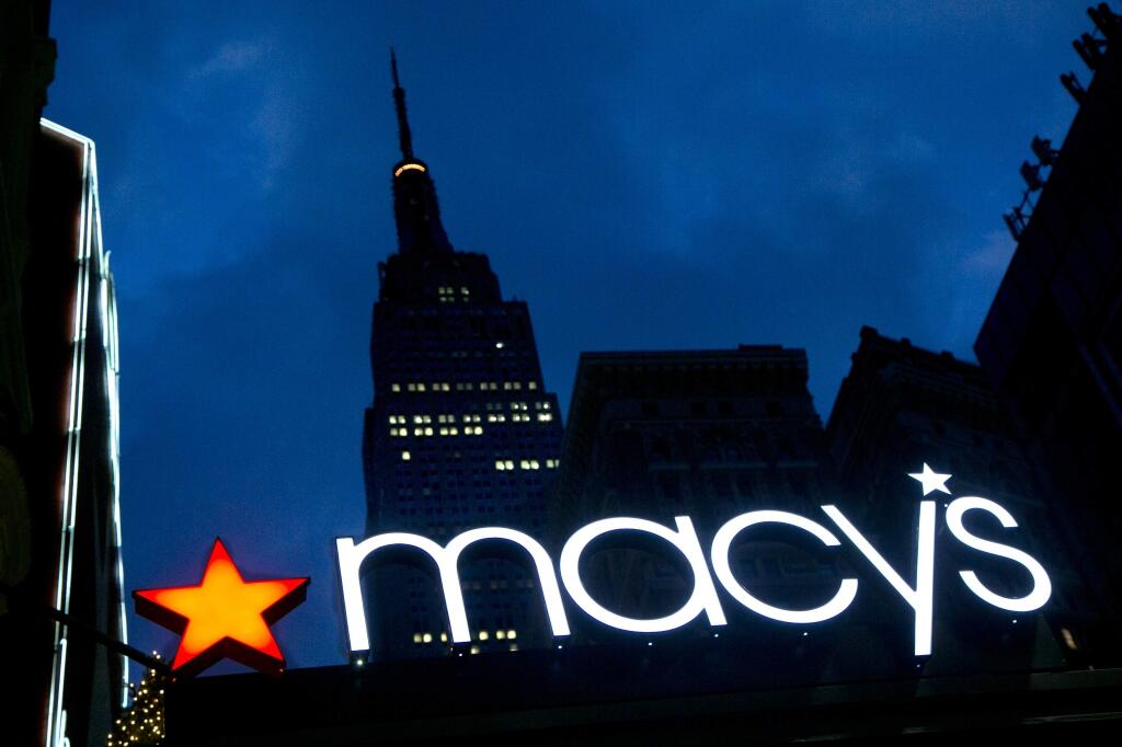 FILE - In this Nov. 21, 2013, file photo, with the Empire State building in the background, the Macy's logo is illuminated on the front of the department store in New York. It turns out there‚Äôs a wealth gap among companies, just like among people. Of the $1.8 trillion in cash that‚Äôs sitting in U.S. corporate accounts, half of it belongs to just 25 of the 2,000 companies tracked by S&P Global Ratings. In March 2016, S&P cut its ratings on Macy's to BBB, two notches above junk, as competition from internet retailers continues to dig into the department store chain's sales. (AP Photo/Mark Lennihan, File)