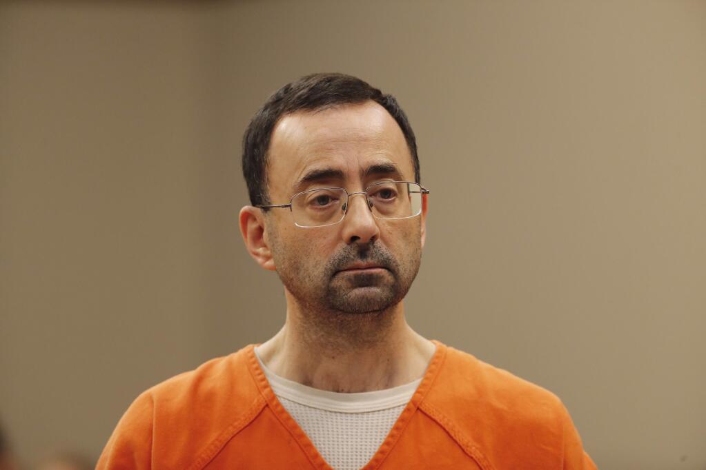 FILE - In this Nov. 22, 2017, file photo, Dr. Larry Nassar, appears in court for a plea hearing in Lansing, Mich. Nassar, an elite Michigan sports doctor who possessed child pornography and assaulted gymnasts, was sentenced Thursday, Dec. 7, 2017, to 60 years in federal prison in one of three criminal cases that ensure he will never be free again. (AP Photo/Paul Sancya, File)
