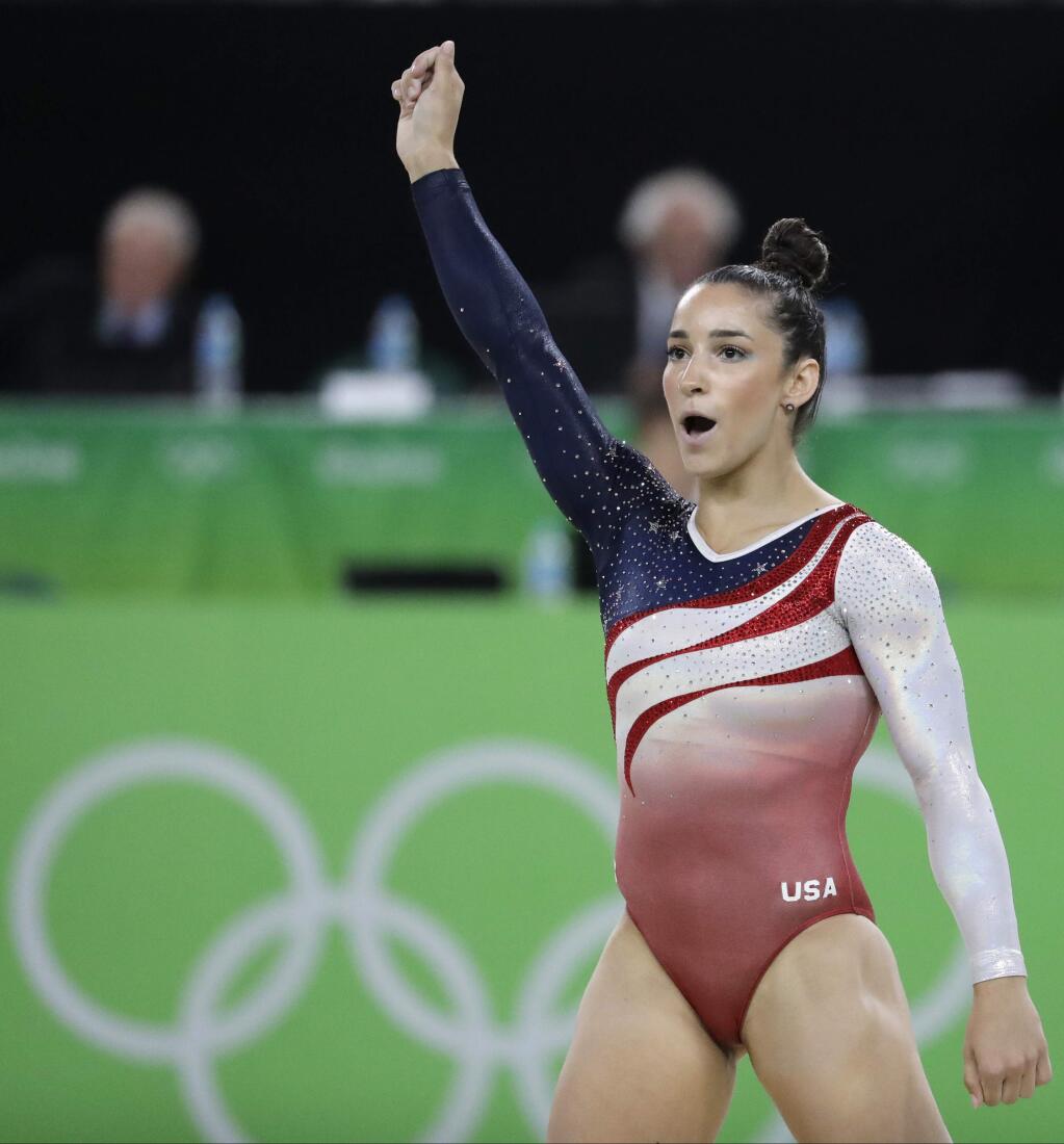 FILE - In this Aug. 9, 2016. file photo, United States' Aly Raisman celebrates after her performance on the floor during the artistic gymnastics women's team final at the 2016 Summer Olympics in Rio de Janeiro, Brazil. Six-time Olympic medalist Aly Raisman is suing the U.S. Olympic Committee and USA Gymnastics, claiming both organizations 'knew or should have known' about abusive patterns by a disgraced former national team doctor now in prison for sexually abusing young athletes.Raisman filed the lawsuit in California on Wednesday, Feb. 28, 2018. (AP Photo/Charlie Riedel, File)