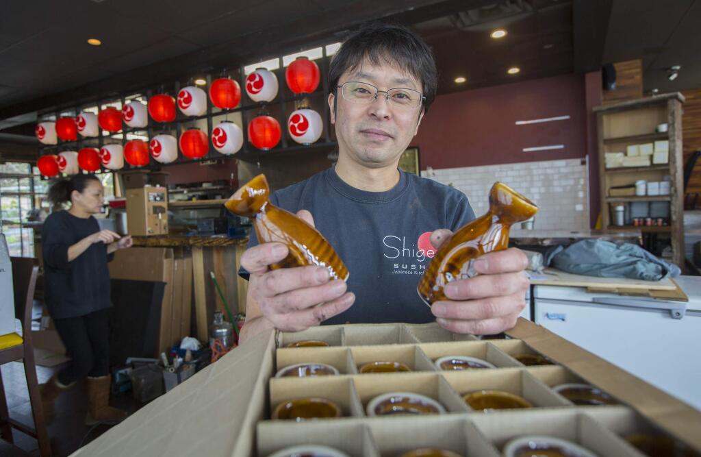 Unpacking sake containers at the new sushi restaurant in Maxwell Village. (Photo by Robbi Pengelly/Index-Tribune)