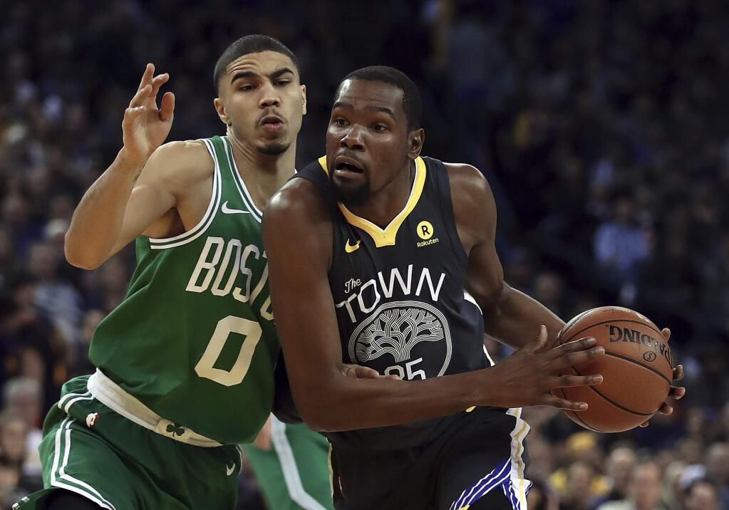 The Golden State Warriors' Kevin Durant, right, drives the ball against Boston Celtics' Jayson Tatum during the first half Saturday, Jan. 27, 2018, in Oakland. (AP Photo/Ben Margot)