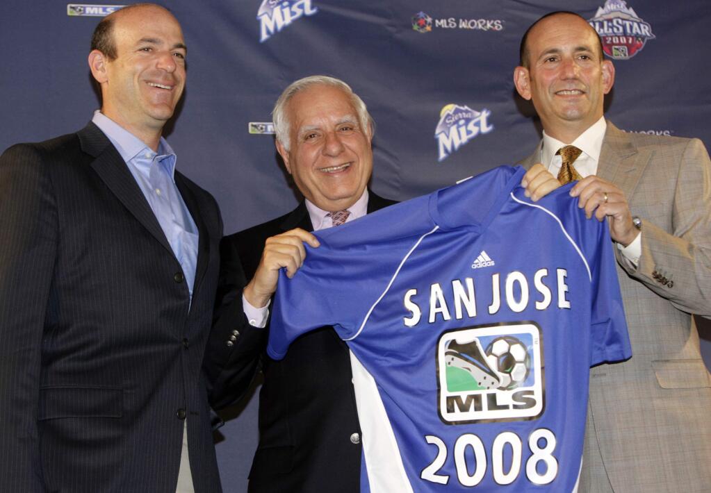 In this July 18, 2007, file photo, Don Garber, right, commissioner of Major League Soccer, joins the new owners of the San Jose Earthquakes, Lew Wolff, center, and John Fisher, left, in holding up a jersey for the expansion team during a news conference in the northeast Denver suburb of Commerce City, Colo. Wolff is selling all but a small stake in the Oakland Athletics and giving up his managing partner role, turning over leadership of the franchise to Fisher as the club seeks a new ballpark location. (AP Photo/David Zalubowski, file)