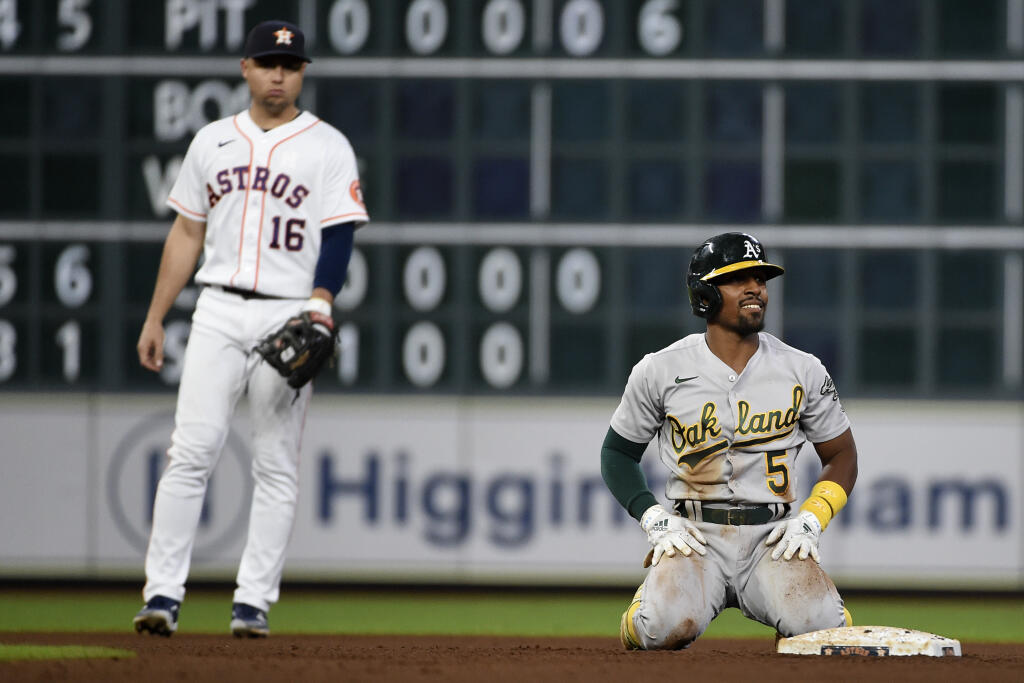 Oakland Athletics' Tony Kemp (5) reacts after being tagged out by Houston Astros second baseman Jose Altuve trying to stretch a single into a double as shortstop Aledmys Diaz (16) watches during the fifth inning of a baseball game, Saturday, Oct. 2, 2021, in Houston. (AP Photo/Eric Christian Smith)