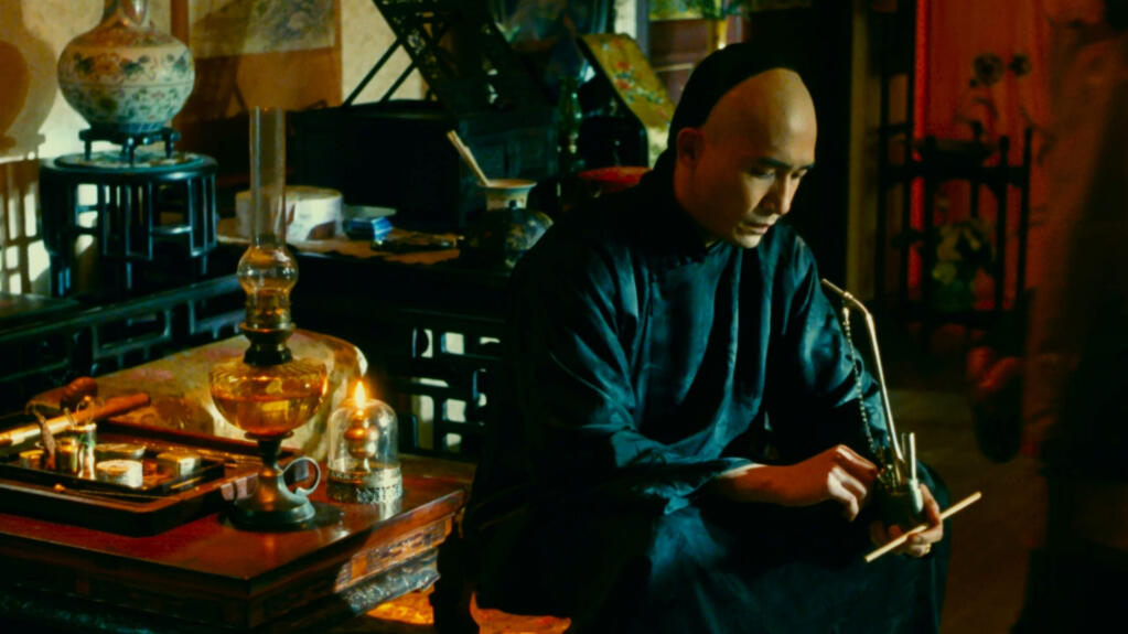 Tony Leung Chiu-wai in 'Flowers of Shanghai' (1998), where ornate doors to the outside world are cracked open, but the women of the flower house never walk through. (High On Films)
