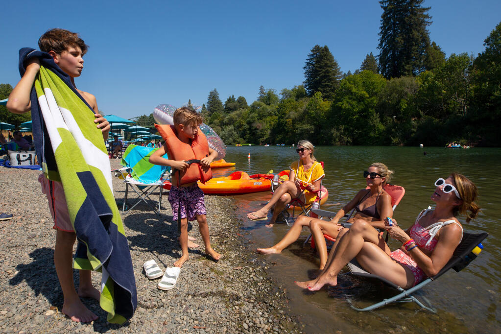 Jenny Mayfield, at lower right, of San Francisco, talks with her son, Henry Rubenstein, 8, while enjoying part of their Labor Day weekend with friends Merrill Gillespie, second from right, Shannon Foote, and Whit Gillespie, 6, at Johnson's Beach in Guerneville, on Saturday, Sept. 5, 2020. (Alvin A.H. Jornada / The Press Democrat)