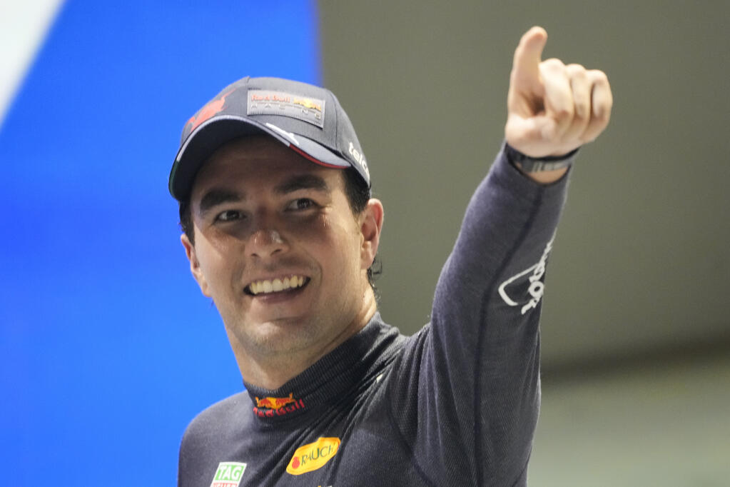Red Bull driver Sergio Perez of Mexico celebrates after winning the Singapore Formula One Grand Prix, at the Marina Bay City Circuit in Singapore, Sunday, Oct.2, 2022. (AP Photo/Vincent Thian)