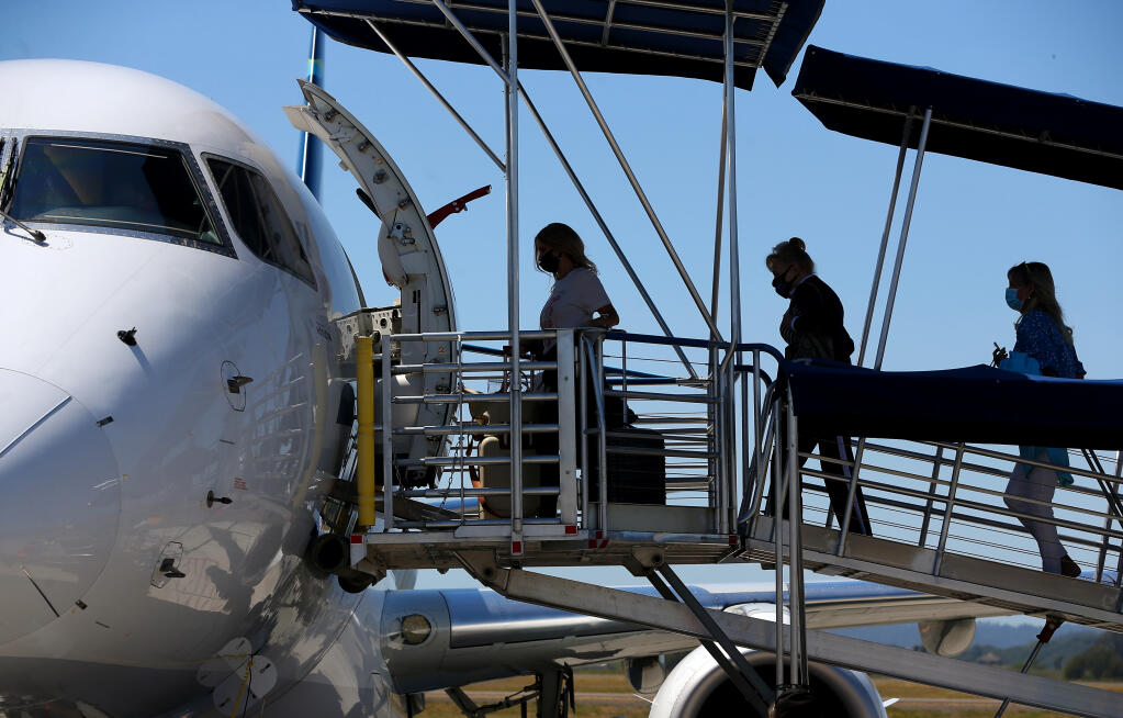 Travelers board an Alaska Airlines flight bound for Orange County, at the Charles M. Schulz-Sonoma County Airport in Santa Rosa on Thursday, April 15, 2021.  (Christopher Chung/ The Press Democrat)