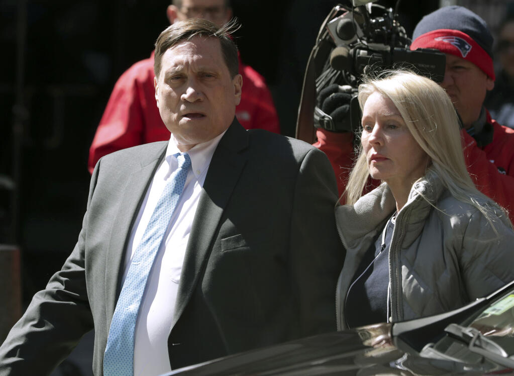 FILE — Investor John Wilson, left, arrives at federal court in Boston with his wife Leslie in this Wednesday, April 3, 2019 file photo, to face charges in a nationwide college admissions bribery scandal. The first trial in the college admissions bribery scandal opened Monday, Sept. 13, 2021, with defense attorneys seeking to portray the two parents accused of buying their kids' way into school as victims of deception who believed their payments were legal donations. (AP Photo/Charles Krupa, File)