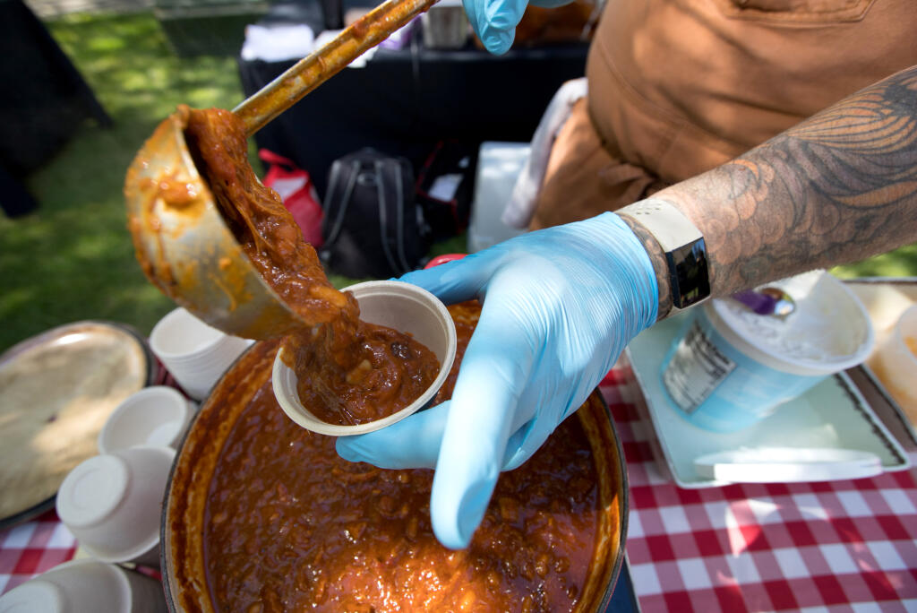 Chef Ben Lacy of South Yard at Napa Valley Marriott pours his chili called “Smokehouse Brisket and Pulled Pork” during the inaugural Chili Challenge benefiting World Central Kitchen at Cline Family Cellars, Sunday, September 10, 2023 in Sonoma. (Darryl Bush / For The Press Democrat)