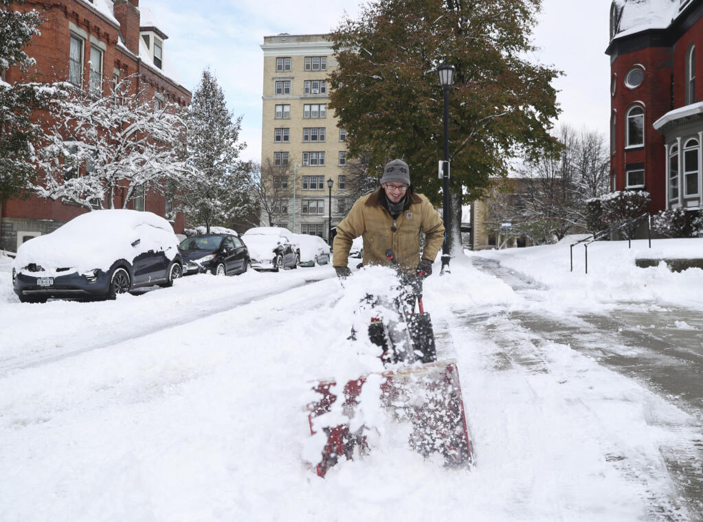 Nicholas Harelick tries to clear a sidewalk with a snowblower, Friday, Nov, 18, 2022, in Buffalo, N.Y. A dangerous lake-effect snowstorm paralyzed parts of western and northern New York on Friday, with nearly 2 feet (0.61 meters) of snow already on the ground in some places by midmorning and possibly much more on the way. (Joseph Cooke/The Buffalo News via AP)