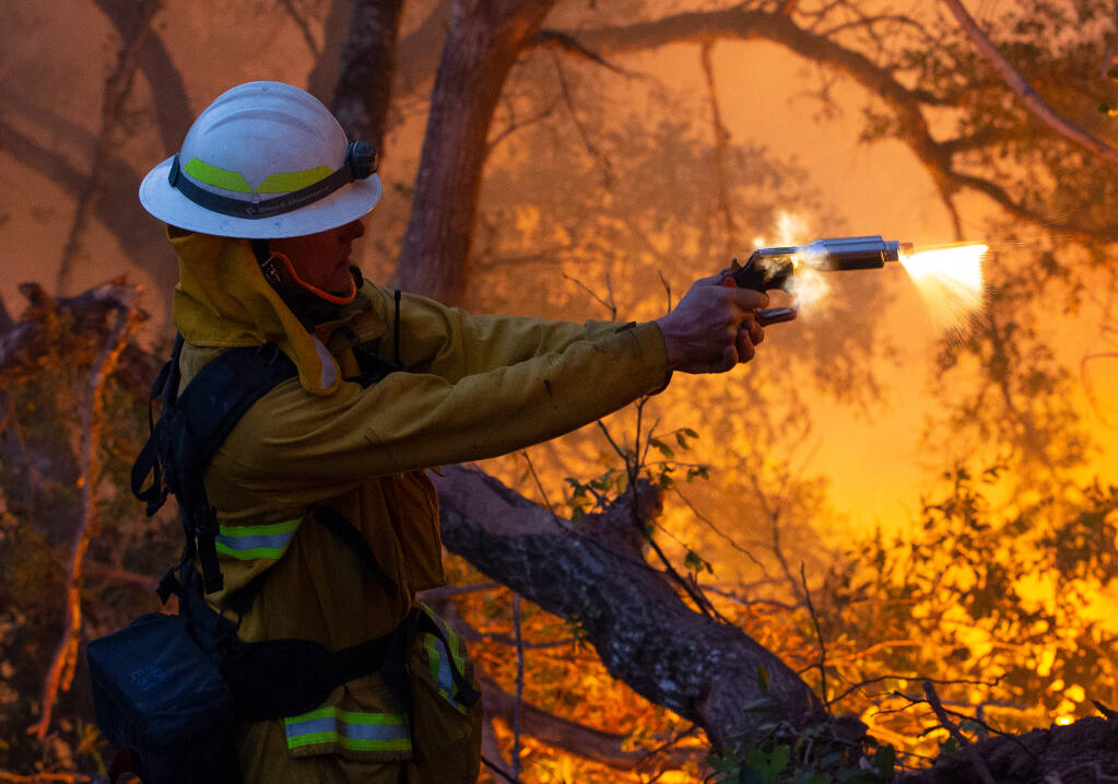 San Bruno Fire battalion chief Bill Forester fires a flare gun down a ravine during a defensive firing operation at Sugarloaf Ridge State Park to create a buffer between the head of the Glass Fire and adjacent communities near Kenwood, California, on Tuesday, September 29, 2020. (Alvin A.H. Jornada / The Press Democrat)