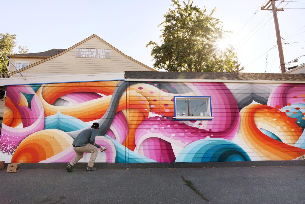 Ricky Watts, a Sebastopol-based artist, working on the final touches of his mural on Tia Maria Panaderia y Pasteleria on Sebastopol Road during The Mural Festival in Roseland neighborhood of Santa Rosa, California, on Monday, June 27, 2022. (Erik Castro/For The Press Democrat, 2022)