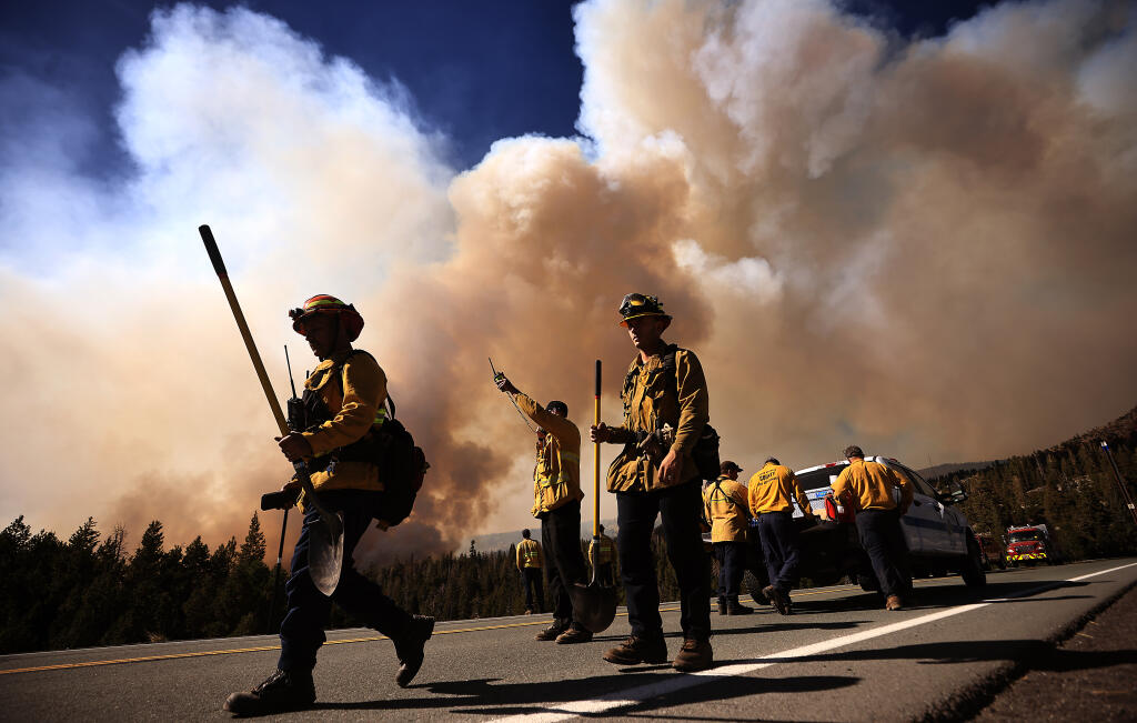Jason Robles and Jordan Abell of the West Covina Fire Department walk back to their engine as the Caldor fire makes a run near Kirkwood Mountain Resort, Wednesday, Sept. 1, 2021.  (Kent Porter / The Press Democrat) 2021