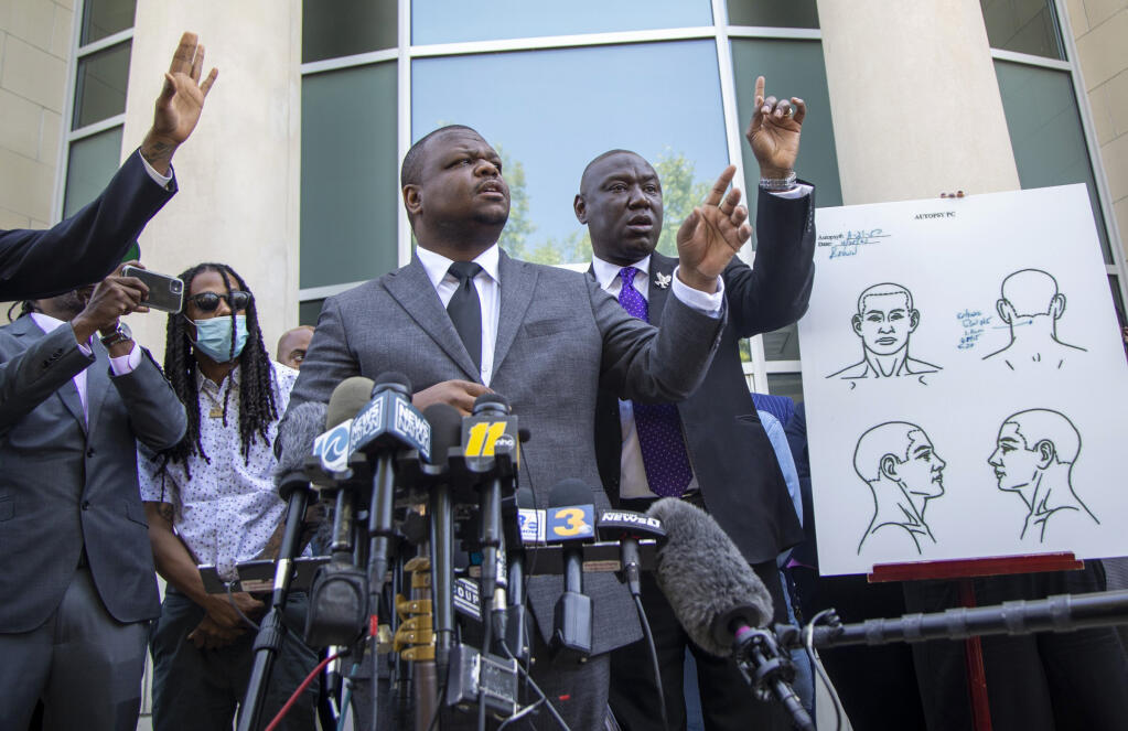 Attorneys for the family of Andrew Brown Jr., including Harry Daniels, center, and Ben Crump take questions from reporters during a press conference outside the Pasquotank County Public Safety building Tuesday, April 27, 2021 to announce results of the autopsy they commissioned, which they said showed five bullet wounds including one to the back of the head. They accused Pasquotank County officials of hiding information and keeping justice from being served in Elizabeth City.