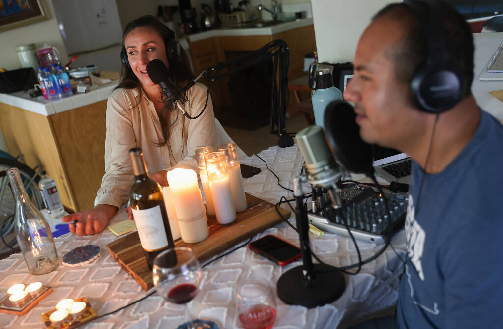 “Sonoma Confidencial” cohost Leticia Romo, left, of Petaluma, joins host Juan Carlos Arenas at his home studio for a recording of their podcast in Santa Rosa on Wednesday, June 16, 2021.  (Christopher Chung/ The Press Democrat)