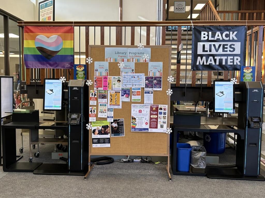 Pride and Black Lives Matters banners hang in front of the self-checkout kiosks at the Central Santa Rosa Regional Library. The Sonoma County Library Commission will discuss whether to create a policy that could potentially take down the banners, which were originally hung by library staff. Amie Windsor photo.