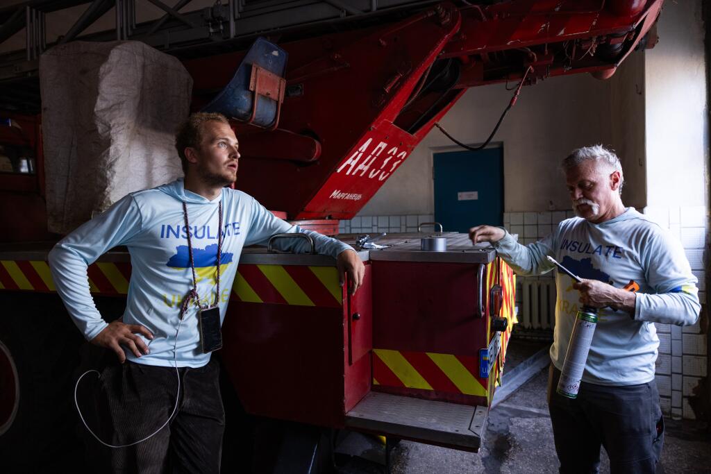 Insulate Ukraine founder Harry Houston, left, and Matthew Rorick, owner of Napa-based Forlorn Hope Wines, prepare to replace a window in an eastern Ukraine fire station as part of a countrywide project to restore an estimated 10 million windows destroyed during the war with Russia. (Courtesy photo)